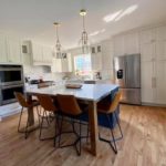 Beautiful transitional inspired kitchen with brushed gold accents, Sherwin Williams Iron Ore island and Calacatta Monaco Quartz counters