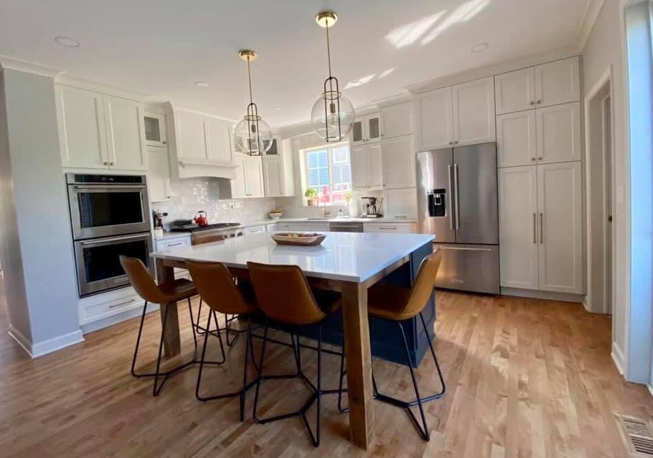 Beautiful transitional inspired kitchen with brushed gold accents, Sherwin Williams Iron Ore island and Calacatta Monaco Quartz counters